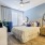 spacious bedroom with large window, ceiling fan and light fixture